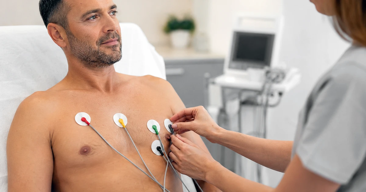Profissional posiciona eletrodos no peito de paciente para o eletrocardiograma