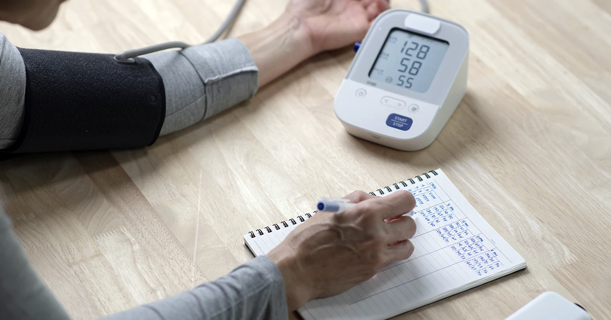Aferição de pressão arterial em casa com registro das medidas em um caderno